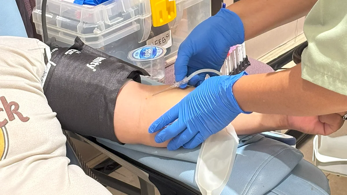 Pendonor duduk tenang sambil mendonorkan darah di event Rumah Berkah 22 Juni 2025, dengan perawatan medis yang memenuhi ketentuan donor darah , seperti penggunaan alat steril dan pemantauan kesehatan selama proses.